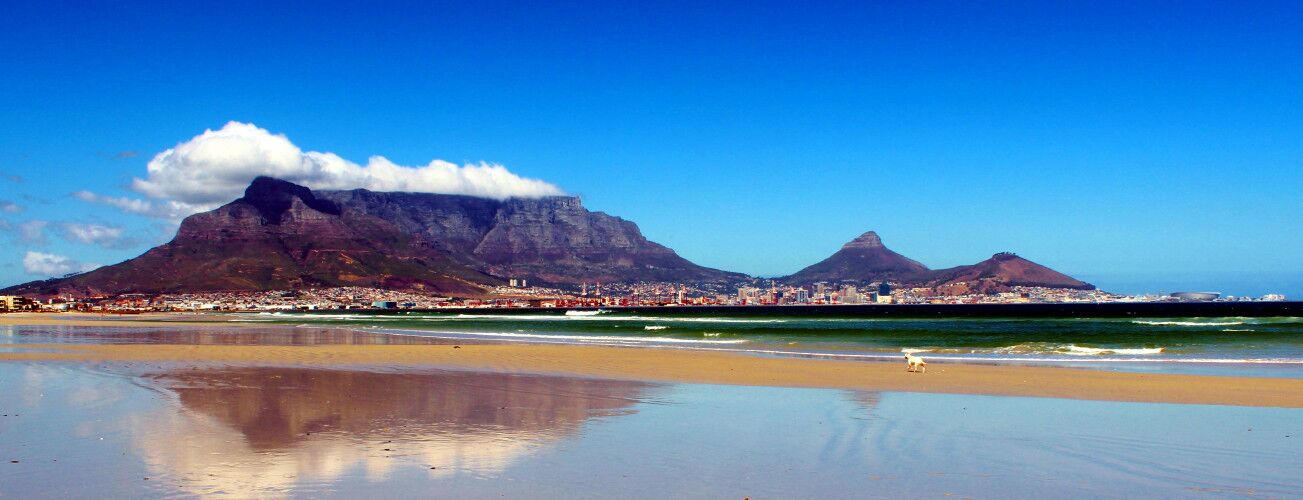 Tafelberg spiegelt sich im nassen Sand am Strand